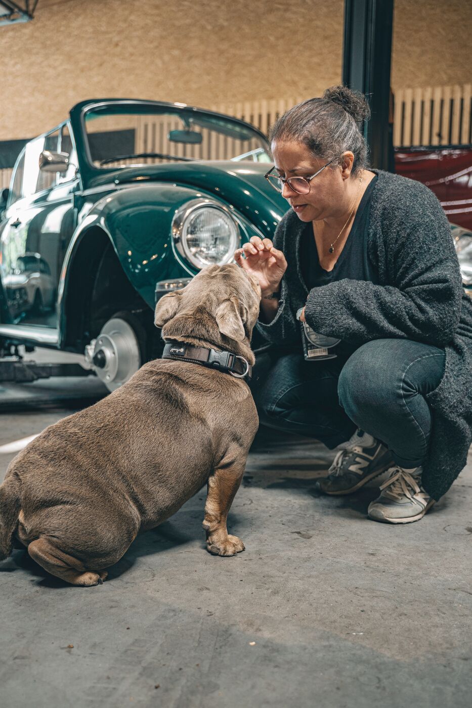 Anna mit Werkstatthund Eddie in der Oldtimer-Werkstatt